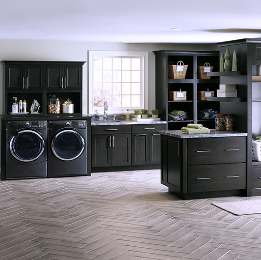 Laundry room with black cabinets and appliances.