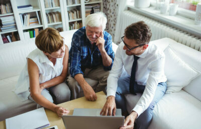 Three people reviewing proposal on a computer