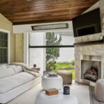 Covered porch with furniture, TV and fireplace