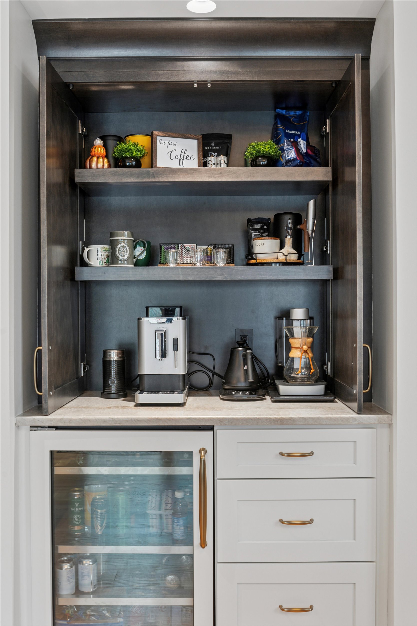 Custom Pantry Cabinetry with Wine Storage and Woven Basket Organization A built-in pantry cabinet with white shaker doors, a top wine storage cubby, wood countertops, and organized lower shelves with woven baskets and clear storage bins.